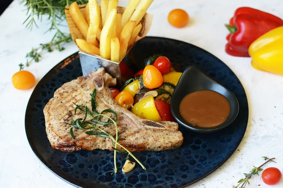 Pork Chop with Peppercorn Sauce served with Grilled Vegetables and French Fries