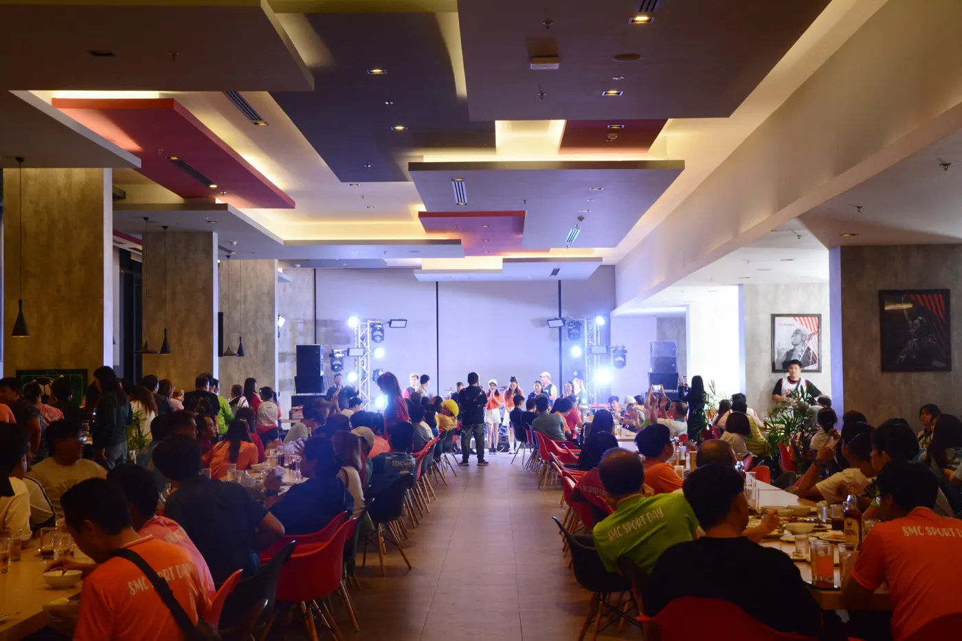 公司宴会坐满整个宴会空间，舞台上有现场乐队